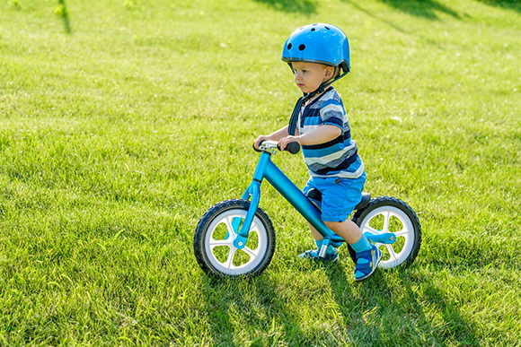 dziecko w kasku na rowerku biegowym